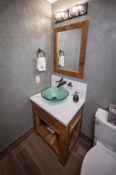 a bathroom with a sink, mirror and toilet