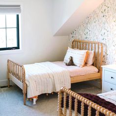 two twin beds in a bedroom with floral wallpaper