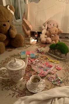 teddy bears and teacups are on the floor in front of a crib