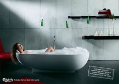 a woman laying in a bathtub filled with foam and bubbles next to shelves on the wall