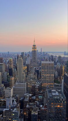 an aerial view of new york city at dusk with the empire building in the foreground