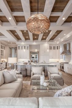 a living room filled with lots of furniture and a chandelier hanging from the ceiling