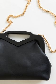 A staple handbag to add to your collection. The Black Triangle Handle Point Bag is made with a magnetic frame, v handle and a gold chain strap to wear on shoulders. The crossbody bag features one zip pocket and two slot pockets. Wear the black chain crossbody bag from everyday wear to special occasions. Luxury vegan leather 12"W x 6.5"H x 2.5"D Handle Drop: 3" Strap Length: 43" Magnetic Closure Gold-Tone Hardware Interior Zip & Slot Pockets Cotton Lining Fits up to an iPhone 11 Pro Max Evening Pouch Satchel With Chain Strap, Evening Satchel With Chain Strap In Pouch Shape, Evening Satchel With Chain Strap And Pouch Shape, Evening Satchel With Chain Strap Pouch, Everyday Shoulder Clutch With Chain, Everyday Pouch Clutch With Chain Strap, Chic Satchel With Chain Strap Shaped As Clutch, Chic Black Clutch With Chain, Modern Black Evening Bag With Chain Strap