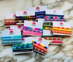 many different colored hair ties on a marble counter with white envelopes in the middle