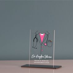 a clear acrylic award with a pink shirt and stethoscope