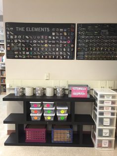 the shelves are filled with plastic containers and bins for storing items in front of two large chalkboards