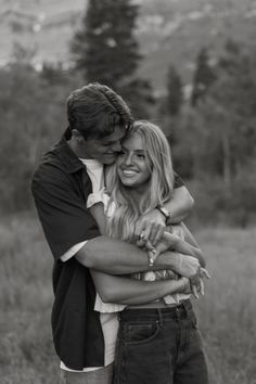 a man and woman hugging each other in a field