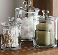 three glass containers with candles and marshmallows in them