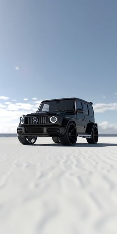 a black jeep is parked in the middle of an empty desert area with blue sky and white clouds