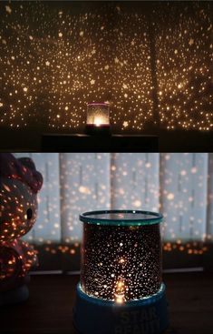 a candle that is sitting in front of a window with stars on the curtain behind it