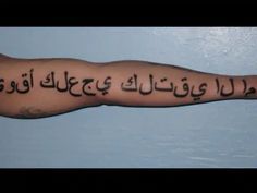 an arm with arabic writing on it, and the words written in two different languages