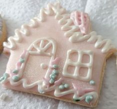 there is a pink and white decorated gingerbread house