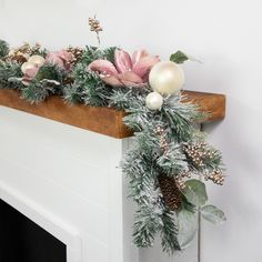 a fireplace mantel decorated with greenery and ornaments