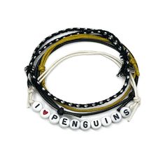 I Love Penguins bracelet with black, white and gold cords featuring letter beads and a penguin-themed charm. Music Note Bracelet, Penguin Bracelet, Shark Jewelry, Music Bracelet, Letter Bead Bracelets, Bracelet Pack, Penguin Love, Black White And Gold, Bracelet Knots