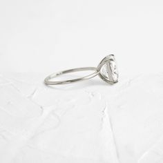 a diamond ring sitting on top of a white surface