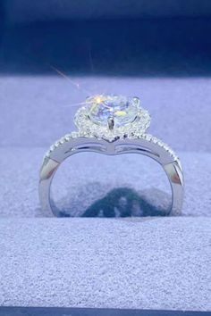 a diamond ring is sitting on display in a box with the light shining through it