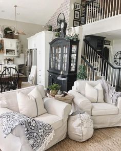 a living room filled with white furniture and lots of pillows on top of it's couches