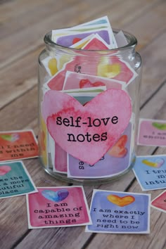 a jar filled with lots of cards sitting on top of a wooden table