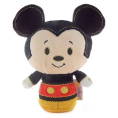 a mickey mouse stuffed animal is wearing a red and black outfit with gold trimmings