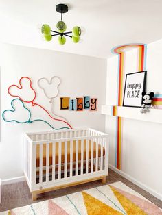 a baby's room with mickey mouse wall art