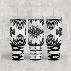 three black and white tumblers with designs on the sides, one has a straw in it