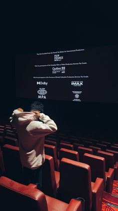 a person standing in front of a screen with his arms crossed and looking at it