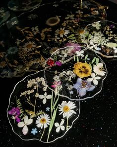 three glass plates with flowers on them are sitting on a table top in the dark