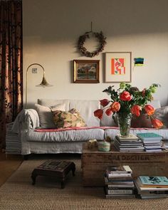 a living room filled with lots of furniture and flowers on top of a coffee table