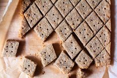 crackers are arranged on a piece of parchment paper next to some cut up squares