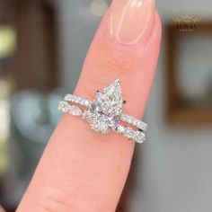 a woman's hand with a diamond ring on top of her finger and an engagement band