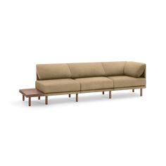 a beige couch sitting on top of a wooden table