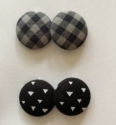 three buttons with white and black designs are on the table next to each other,