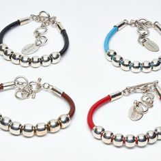 These genuine leather bangles are embellished by 7 sterling silver beads in the center.  The beads measure 10MM in diameter and have a high shine finish.  The easy to use and secure T toggle can be clasped to one of 3 loops, which makes it a perfect unisex bracelet that fits a variety of wrists. 

Choose between 4 colors of leather: black, chocolate brown, red or turquoise.

Matching necklace is 18 inches long, which can be lengthened to 20 inches.  
Necklace is NED202  and it's $270 Beaded Leather Bracelet, Black Chocolate, Leather Bangle, Unisex Bracelets, Bead Leather, Matching Necklaces, Silver Bangles, Sterling Silver Bead