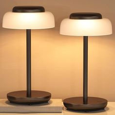 two lamps sitting on top of a table next to each other