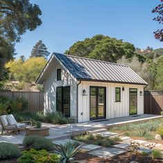 a small white house sitting in the middle of a garden