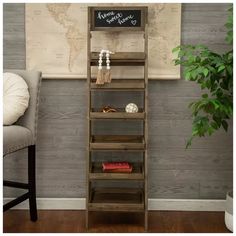 a tall wooden shelf sitting in front of a chair next to a wall with a map on it