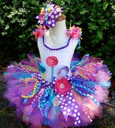 a white mannequin with purple, blue and pink tutu skirt on it