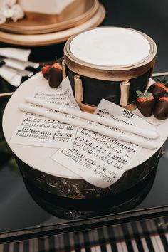 a cake with musical notes and strawberries is on top of a piano sheet tray