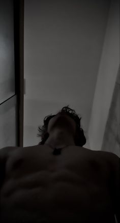 a shirtless man laying in bed with his eyes closed and head turned to the side