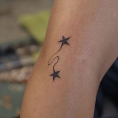 a woman's arm with two stars on it and the word love written in cursive writing