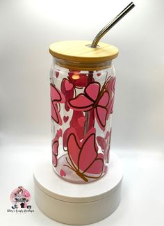 a glass jar with pink hearts and a straw in it