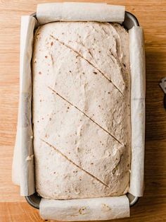 a loaf of bread sitting in a pan on top of a wooden table