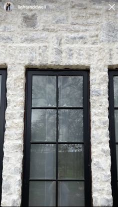 two windows with black panes on the side of a building