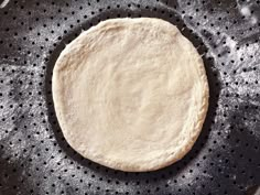 an uncooked pizza dough in a pan