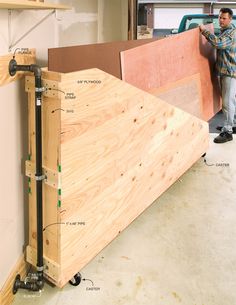 a man standing next to some plywood boards