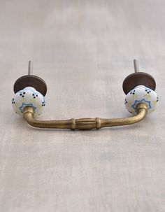 a pair of brass hooks with painted balls on them