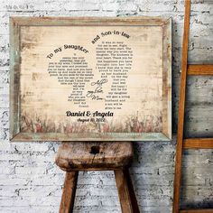 a wooden stool next to a brick wall with a framed poem in the shape of a heart