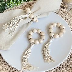 two wooden beads on a white plate next to a drawsack bag and some greenery