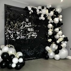 black and white balloons in front of a party backdrop