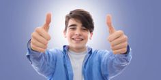 a young man is giving the thumbs up sign with his hands in front of him